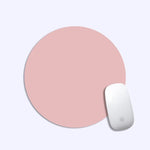 Pink round mouse pad with a white mouse on a light gray background